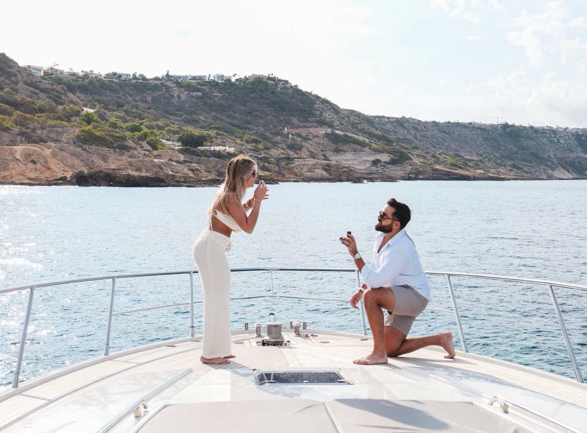A proposal on the bow of a charter yacht at anchor